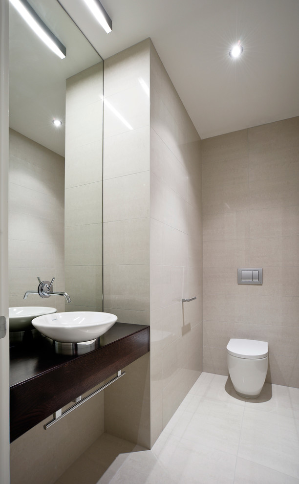 Moderne Gästetoilette mit Aufsatzwaschbecken, Waschtisch aus Holz, beigen Fliesen, Porzellanfliesen, Toilette mit Aufsatzspülkasten und brauner Waschtischplatte in Auckland