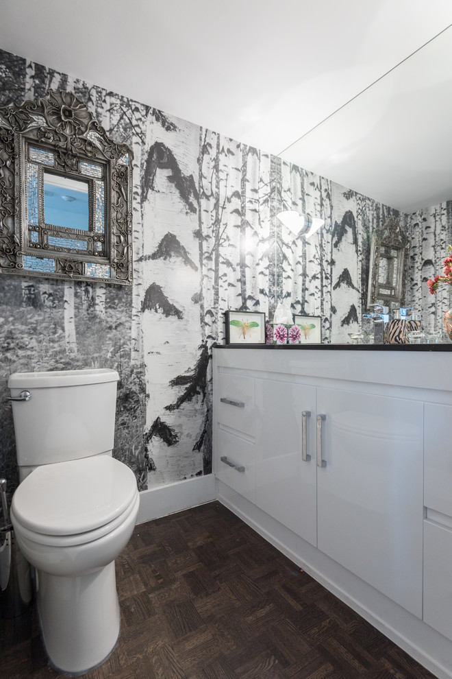 Immagine di un piccolo bagno di servizio design con ante lisce, ante bianche, WC monopezzo, parquet scuro, top in quarzite, pareti multicolore, lavabo sottopiano e pavimento marrone