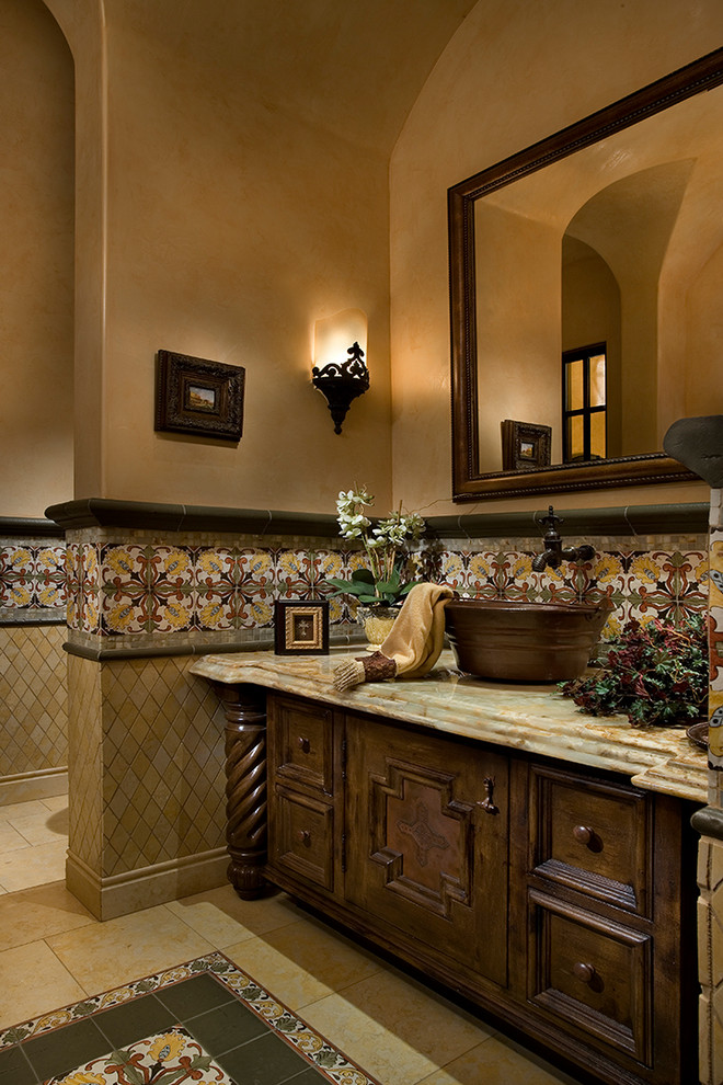 Inspiration for a huge timeless multicolored tile and mosaic tile travertine floor and multicolored floor powder room remodel in Phoenix with furniture-like cabinets, distressed cabinets, a one-piece toilet, brown walls, a vessel sink, quartzite countertops and brown countertops