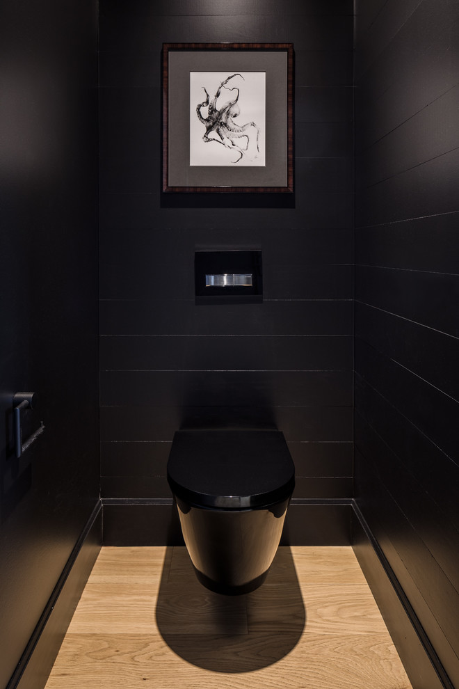 Powder room - large contemporary black tile light wood floor powder room idea in Ottawa with a wall-mount toilet and black walls
