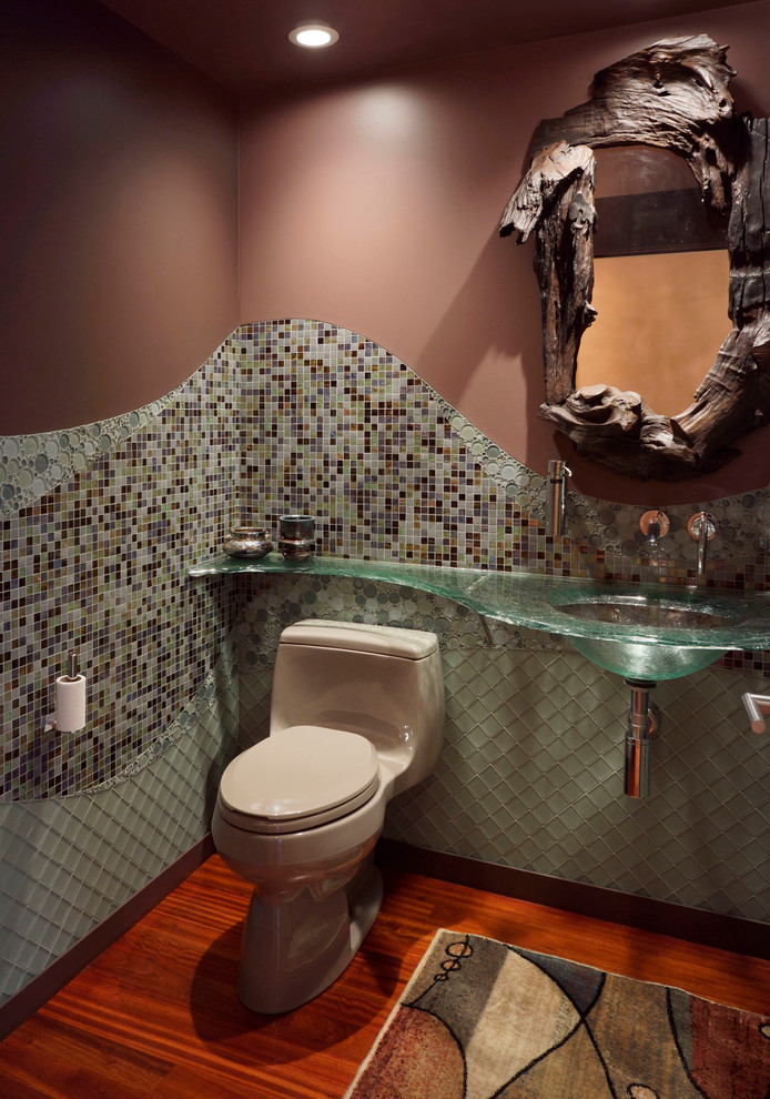 Immagine di un bagno di servizio minimal con piastrelle a mosaico e top in vetro