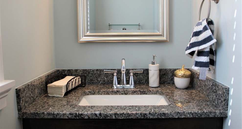 Idee per un piccolo bagno di servizio classico con ante marroni, piastrelle blu e top in granito