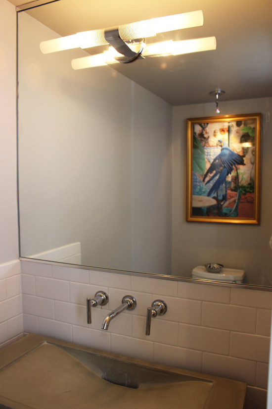 This is an example of a small contemporary cloakroom in New York with white tiles, metro tiles, a two-piece toilet, grey walls and a vessel sink.