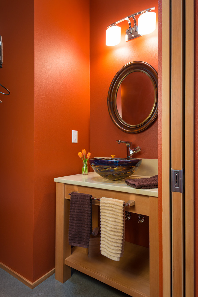 Ejemplo de aseo minimalista pequeño con armarios tipo mueble, puertas de armario de madera oscura, baldosas y/o azulejos blancos, suelo de cemento, lavabo sobreencimera y parades naranjas