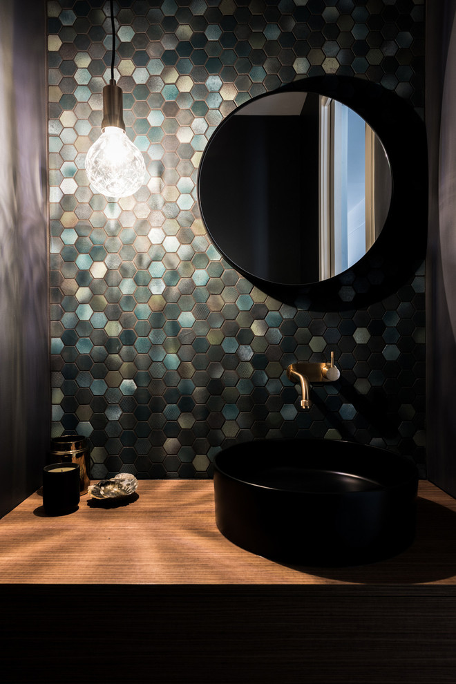 Inspiration for a small contemporary cloakroom in Melbourne with flat-panel cabinets, medium wood cabinets, a one-piece toilet, green tiles, mosaic tiles, green walls, a vessel sink, wooden worktops and brown worktops.