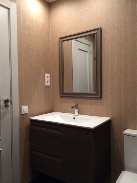 Photo of a small classic cloakroom in Madrid with flat-panel cabinets, dark wood cabinets, a two-piece toilet, beige walls and an integrated sink.