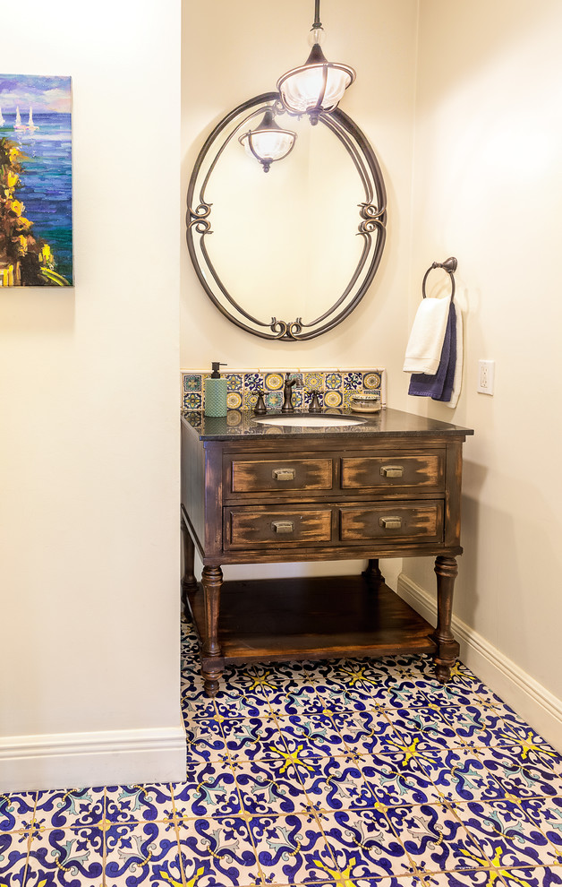 Exempel på ett mellanstort medelhavsstil toalett, med möbel-liknande, skåp i slitet trä, flerfärgad kakel, porslinskakel, vita väggar, mosaikgolv och granitbänkskiva