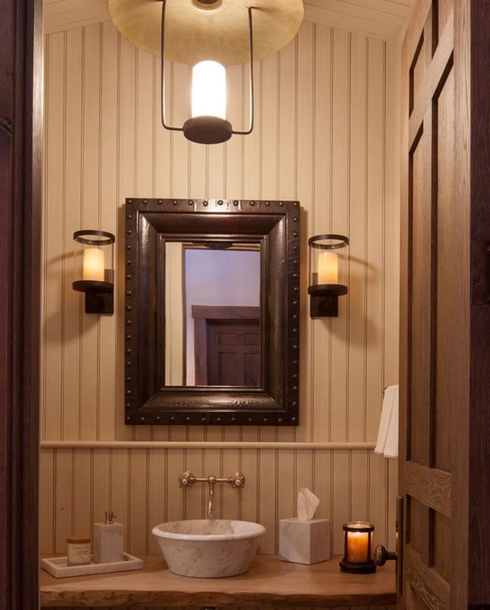 Lantlig inredning av ett litet beige beige toalett, med öppna hyllor, skåp i mellenmörkt trä, beige väggar, mörkt trägolv, ett fristående handfat, träbänkskiva och brunt golv