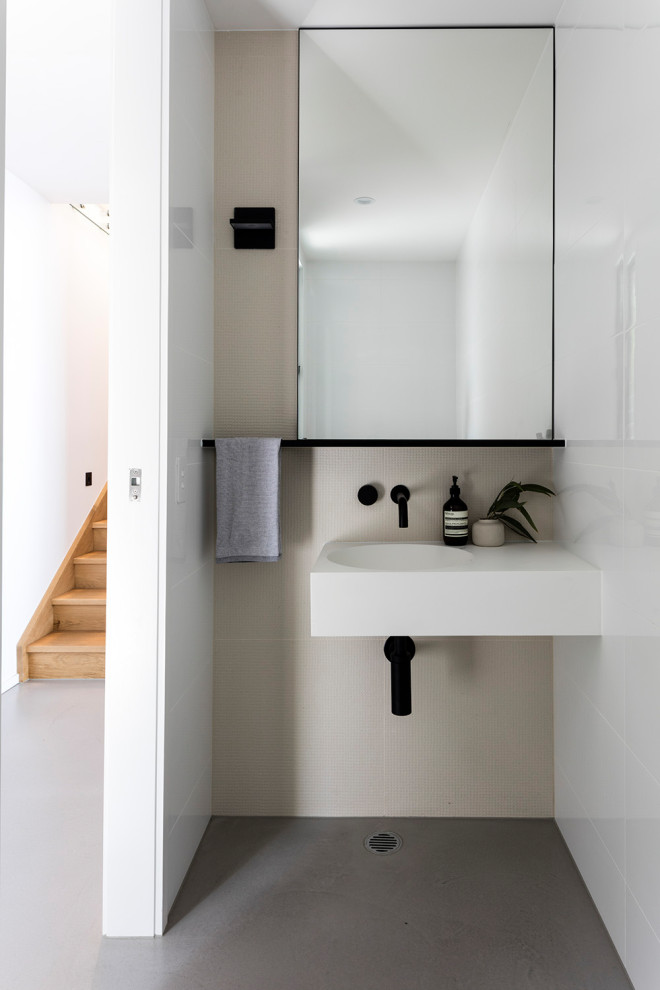 Идея дизайна: туалет в стиле модернизм с бежевой плиткой, бетонным полом, монолитной раковиной, серым полом и белой столешницей