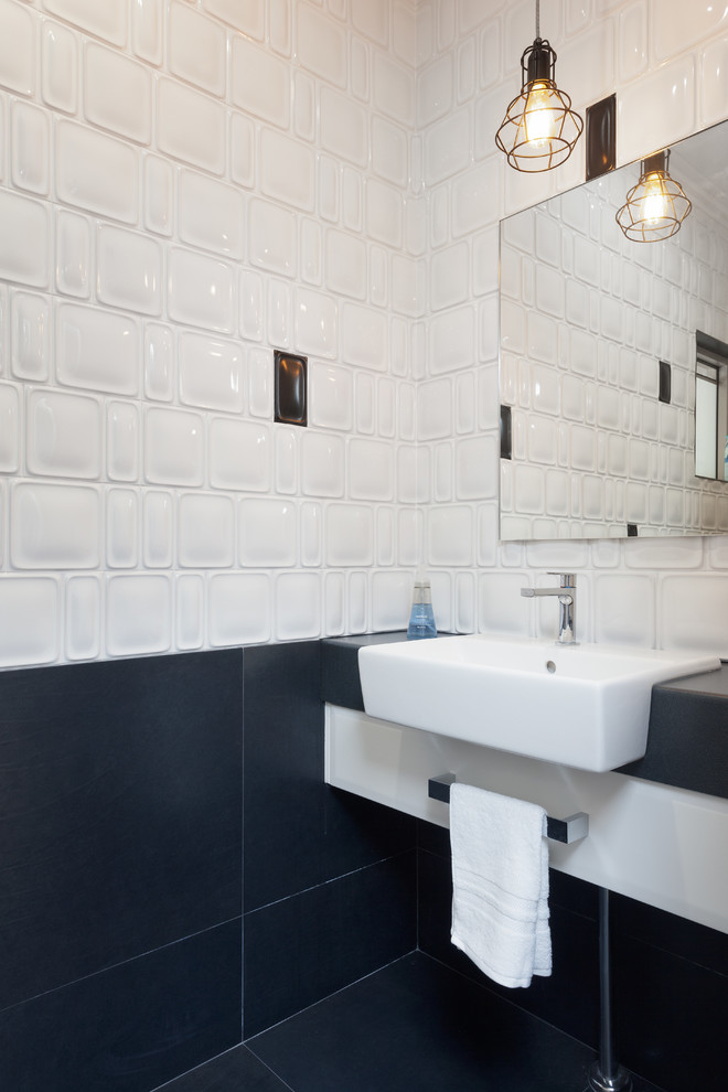 Свежая идея для дизайна: туалет в стиле модернизм с белыми фасадами, столешницей из ламината, белой плиткой, плоскими фасадами, черной столешницей и раковиной с пьедесталом - отличное фото интерьера