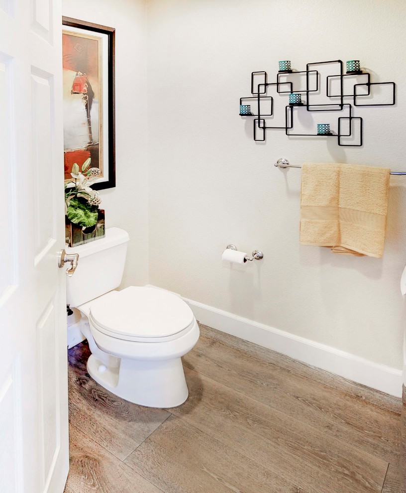 Inspiration för ett litet funkis vit vitt toalett, med en toalettstol med separat cisternkåpa, vit kakel, blå väggar, mellanmörkt trägolv, ett piedestal handfat och grått golv