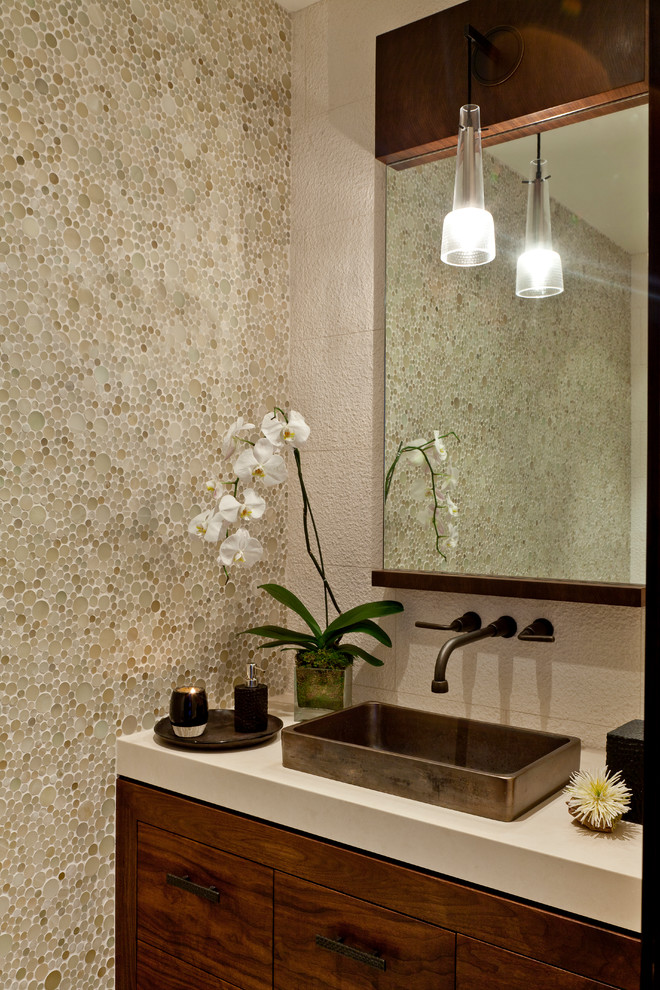 ロサンゼルスにあるラグジュアリーな広いコンテンポラリースタイルのおしゃれなトイレ・洗面所 (濃色木目調キャビネット、石スラブタイル、ベージュの壁、ベッセル式洗面器、ベージュのタイル) の写真