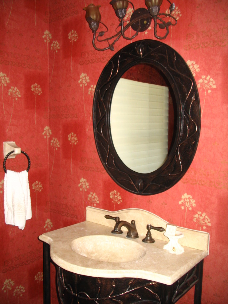 クリーブランドにある小さなトラディショナルスタイルのおしゃれなトイレ・洗面所 (一体型シンク、家具調キャビネット、大理石の洗面台、赤い壁) の写真