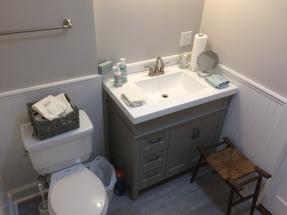 Exempel på ett litet klassiskt toalett, med klinkergolv i porslin, ett integrerad handfat, grått golv, luckor med infälld panel, grå skåp, en toalettstol med separat cisternkåpa, grå väggar och bänkskiva i akrylsten