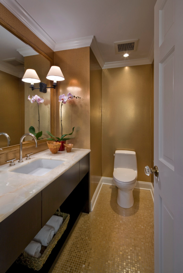 Foto di un bagno di servizio minimal con lavabo sottopiano, ante lisce, ante in legno bruno, top in marmo e WC monopezzo