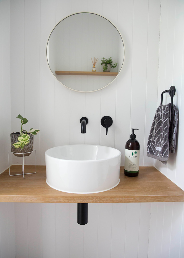 Inspiration pour un WC et toilettes minimaliste en bois clair avec un mur blanc, un lavabo intégré et un plan de toilette en bois.