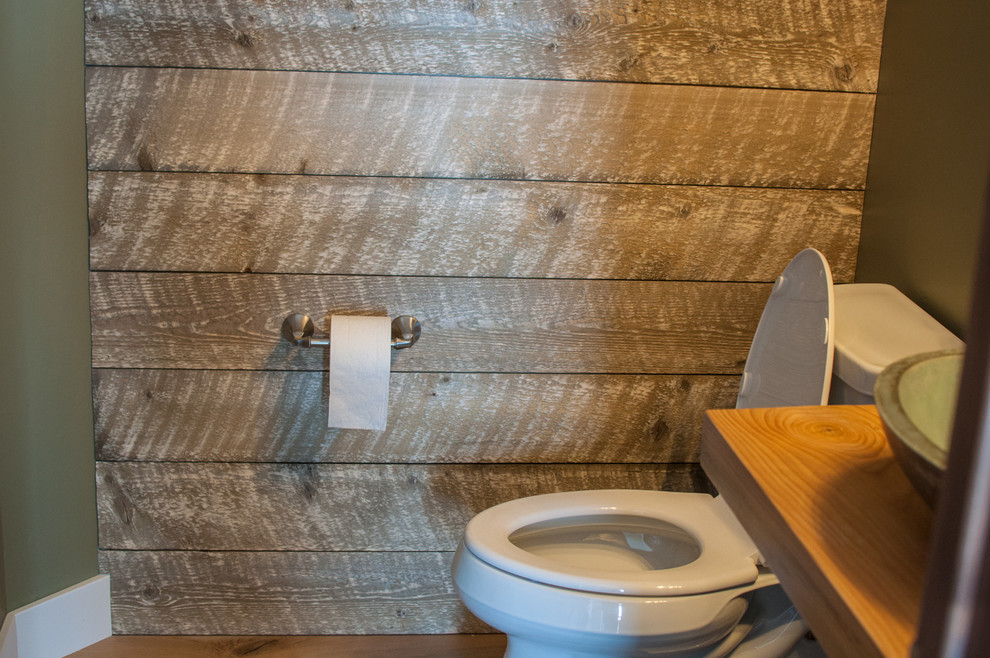 Cette photo montre un WC et toilettes craftsman en bois vieilli avec WC à poser, un mur vert, un sol en calcaire, une vasque et un plan de toilette en bois.