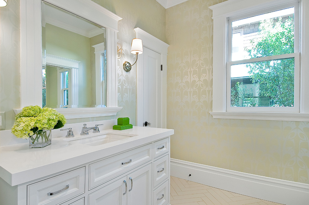 Example of a mid-sized classic porcelain tile and beige floor powder room design in San Francisco with beaded inset cabinets, white cabinets, yellow walls, an undermount sink, solid surface countertops and white countertops