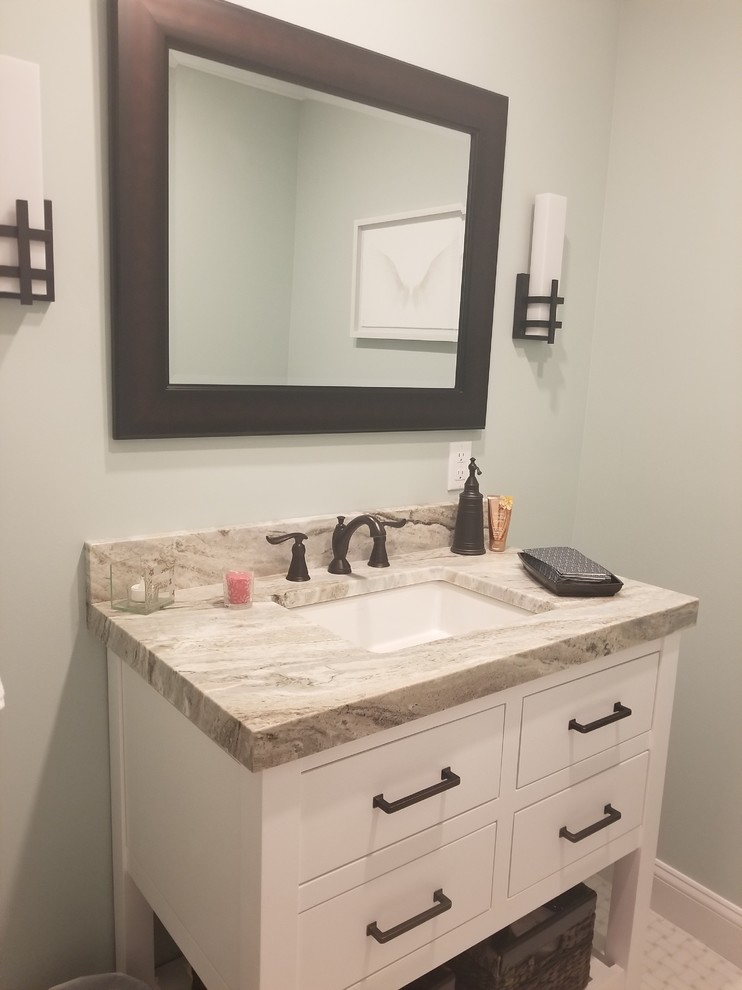 Example of a small trendy ceramic tile and white floor powder room design in New York with flat-panel cabinets, white cabinets, a two-piece toilet, green walls, a drop-in sink, laminate countertops and beige countertops