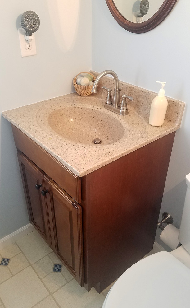Photo of a small traditional cloakroom in Cincinnati with raised-panel cabinets, medium wood cabinets and beige worktops.