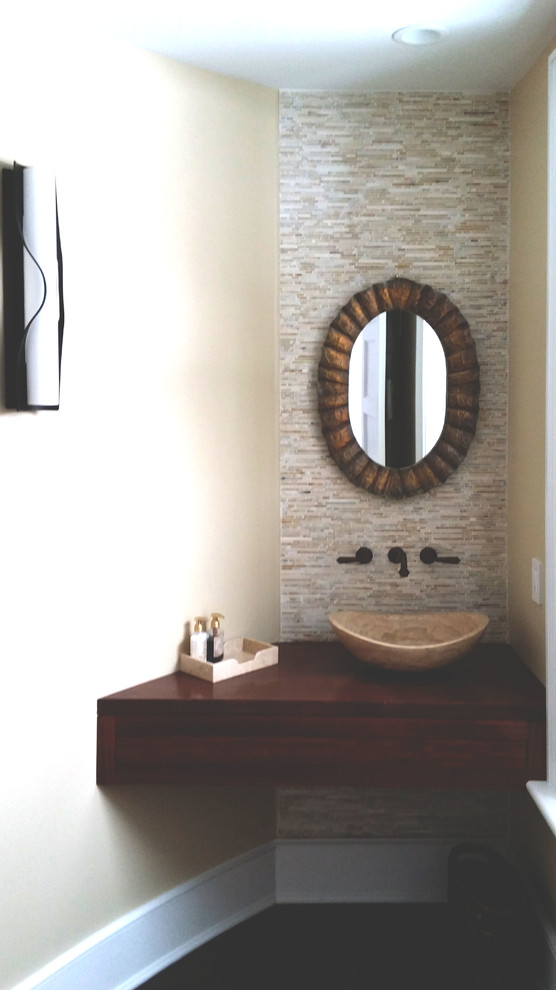 Cette photo montre un petit WC et toilettes tendance avec des portes de placard marrons, un carrelage beige, un mur beige, une vasque, un plan de toilette en bois, un carrelage de pierre, parquet foncé, un sol marron et un plan de toilette marron.