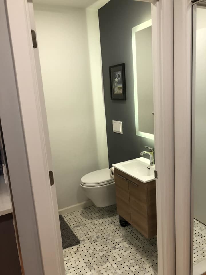 Cette image montre un petit WC suspendu minimaliste en bois brun avec un placard à porte plane, un mur blanc, un sol en marbre, un lavabo intégré, un plan de toilette en quartz modifié, un sol gris et un plan de toilette blanc.