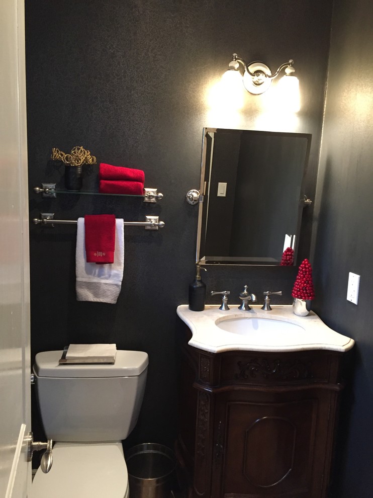 Esempio di un bagno di servizio tradizionale di medie dimensioni con consolle stile comò, ante in legno bruno, WC a due pezzi, pareti nere, lavabo sottopiano e top in quarzite