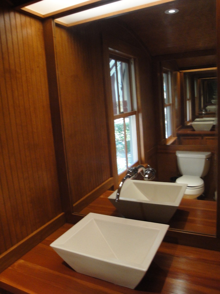 Kleine Moderne Gästetoilette mit verzierten Schränken, hellbraunen Holzschränken, Toilette mit Aufsatzspülkasten, braunen Fliesen, brauner Wandfarbe, Korkboden, Aufsatzwaschbecken, Waschtisch aus Holz, braunem Boden und Porzellanfliesen in New York