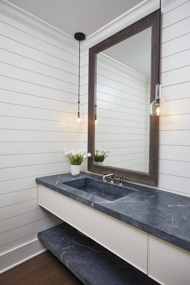Inspiration for a transitional dark wood floor and brown floor powder room remodel in Other with flat-panel cabinets, white cabinets, white walls, an integrated sink and gray countertops