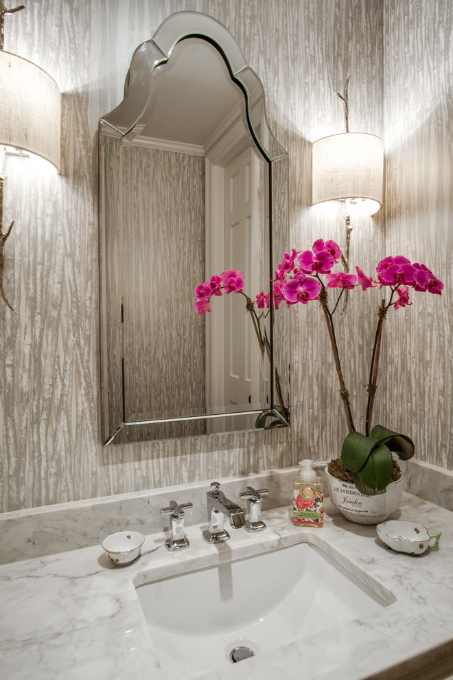 Inredning av ett klassiskt toalett, med beige väggar, ett undermonterad handfat och marmorbänkskiva