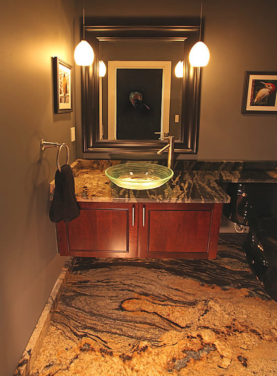 Inspiration for a mid-sized contemporary marble floor powder room remodel in Chicago with recessed-panel cabinets, medium tone wood cabinets, a two-piece toilet, brown walls, a vessel sink and marble countertops