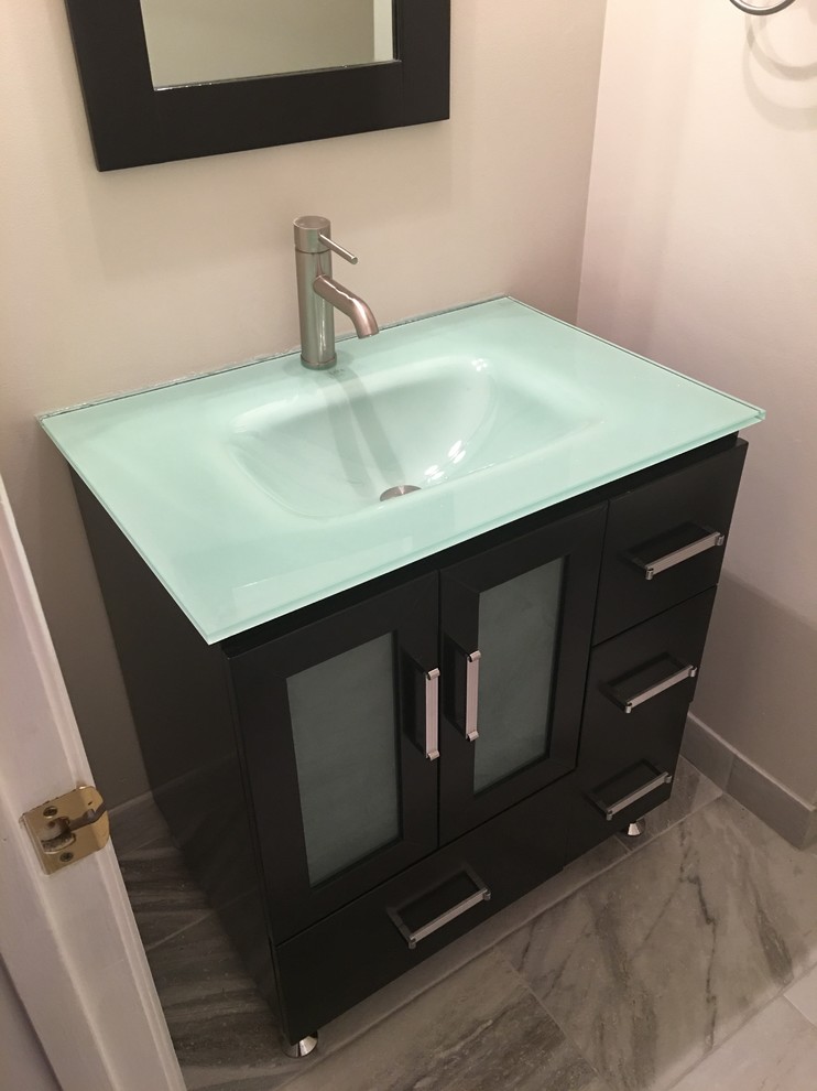 Immagine di un piccolo bagno di servizio minimal con ante di vetro, ante in legno bruno, pareti bianche, pavimento in marmo, lavabo integrato, top in vetro e pavimento grigio