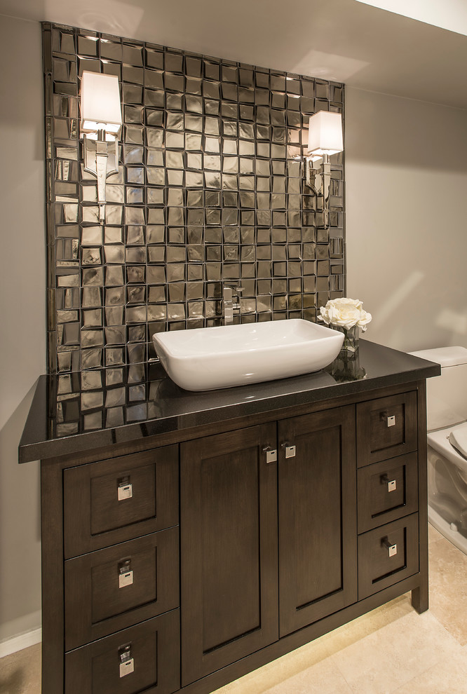 Inspiration for a contemporary glass tile travertine floor powder room remodel in Phoenix with recessed-panel cabinets, dark wood cabinets, a two-piece toilet, gray walls, a vessel sink and granite countertops