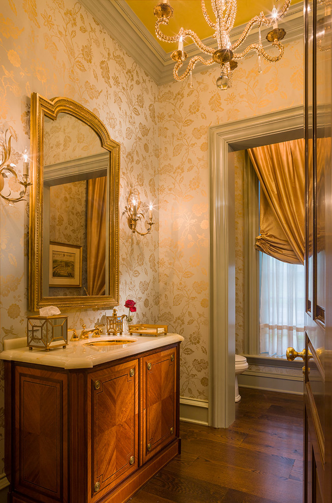 ニューヨークにあるラグジュアリーな中くらいなトラディショナルスタイルのおしゃれなトイレ・洗面所 (アンダーカウンター洗面器、中間色木目調キャビネット、大理石の洗面台、黄色い壁、無垢フローリング) の写真
