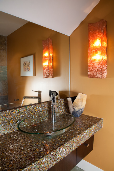 Moderne Gästetoilette mit Aufsatzwaschbecken, flächenbündigen Schrankfronten, dunklen Holzschränken und Recyclingglas-Waschtisch in San Diego