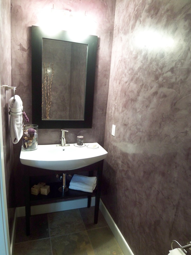 Cette image montre un petit WC et toilettes design avec un mur violet, un sol en ardoise et un lavabo intégré.
