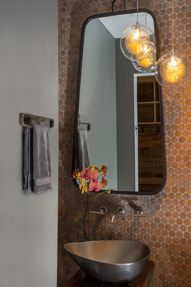 На фото: туалет в современном стиле с коричневой плиткой, плиткой мозаикой, белыми стенами, настольной раковиной, столешницей из дерева и коричневой столешницей