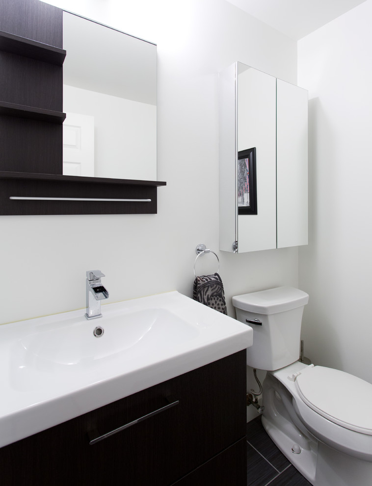 Idéer för att renovera ett litet funkis toalett, med en toalettstol med separat cisternkåpa, svart kakel, porslinskakel, vita väggar, klinkergolv i porslin, släta luckor, skåp i mörkt trä och ett integrerad handfat