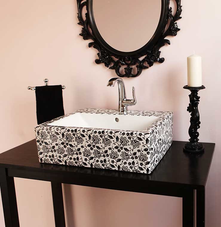 ラスベガスにある低価格の小さなエクレクティックスタイルのおしゃれなトイレ・洗面所 (ピンクの壁、ベッセル式洗面器、家具調キャビネット、黒いキャビネット、ラミネートカウンター) の写真