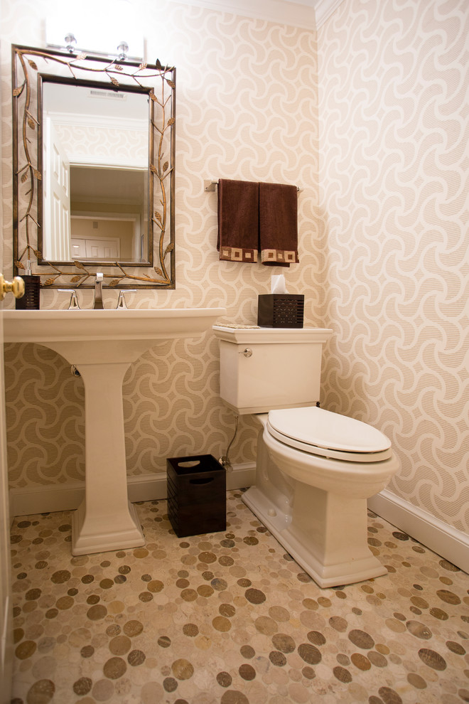 Пример оригинального дизайна: большой туалет в классическом стиле с раздельным унитазом, бежевыми стенами, полом из галечной плитки, раковиной с пьедесталом и коричневым полом