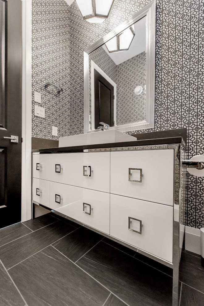 Mittelgroße Moderne Gästetoilette mit Aufsatzwaschbecken, flächenbündigen Schrankfronten, weißen Schränken, Quarzwerkstein-Waschtisch, Toilette mit Aufsatzspülkasten, grauen Fliesen, bunten Wänden und Keramikboden in Calgary