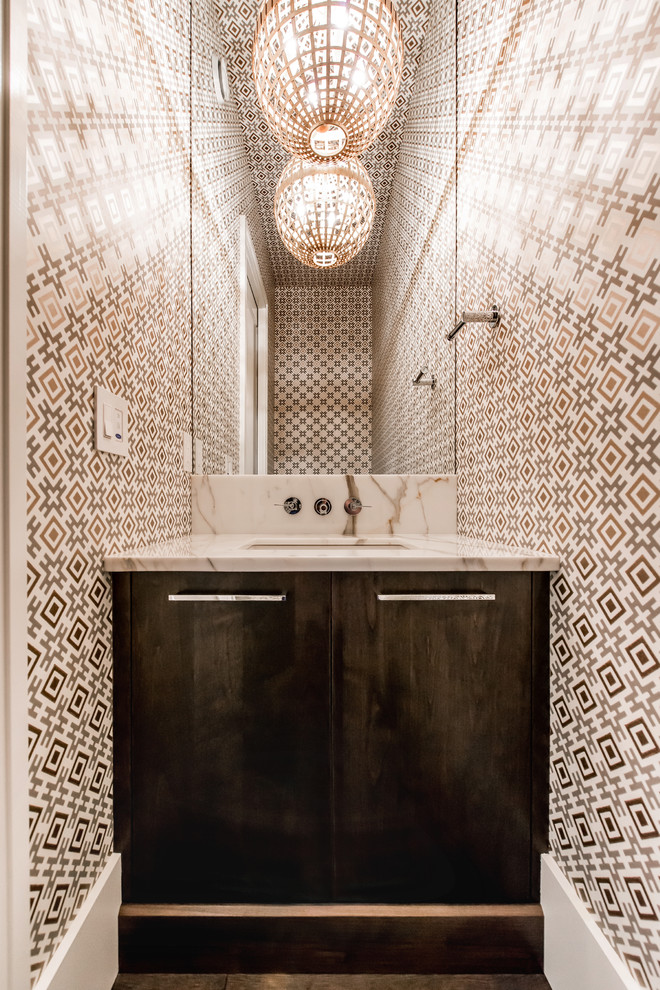 Exempel på ett litet klassiskt toalett, med ett undermonterad handfat, släta luckor, skåp i mörkt trä, marmorbänkskiva, flerfärgade väggar och mellanmörkt trägolv