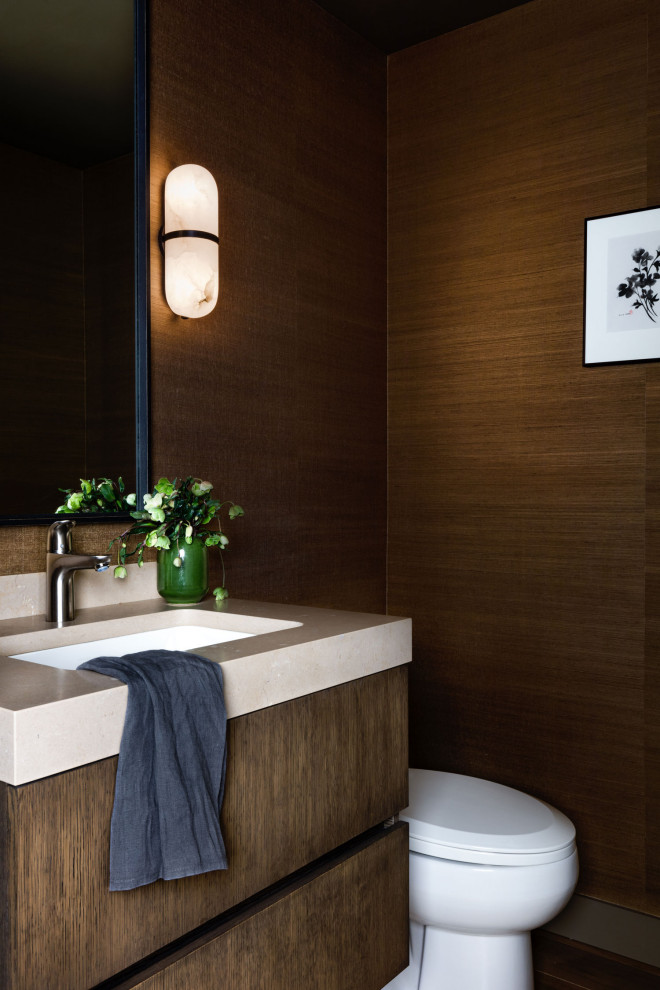 Bild på ett mellanstort funkis beige beige toalett, med släta luckor, skåp i mellenmörkt trä, en toalettstol med separat cisternkåpa, bruna väggar och ett undermonterad handfat