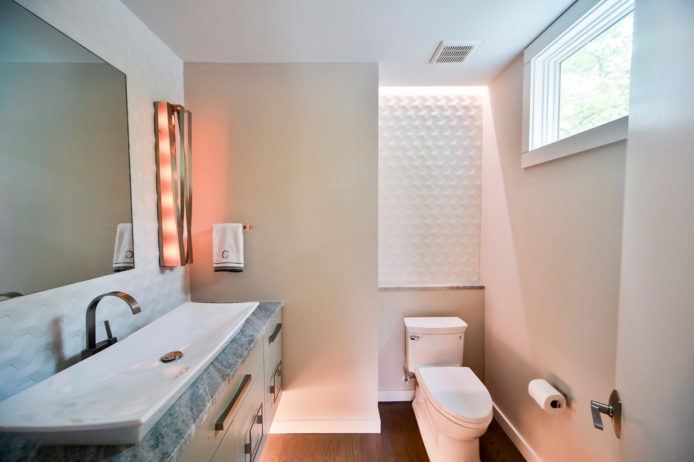 На фото: туалет среднего размера в стиле неоклассика (современная классика) с плоскими фасадами, серыми фасадами, раздельным унитазом, бежевыми стенами, темным паркетным полом, настольной раковиной и столешницей из талькохлорита