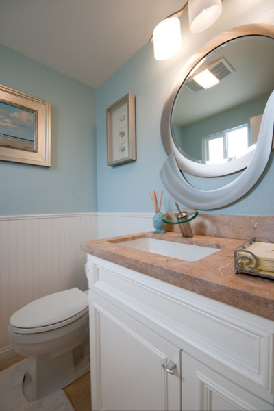 Idéer för ett litet maritimt toalett, med ett undermonterad handfat, luckor med infälld panel, vita skåp, marmorbänkskiva och blå väggar