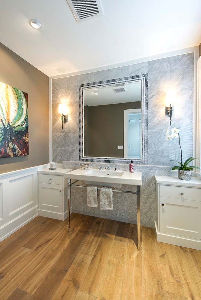 Mittelgroße Klassische Gästetoilette mit Schrankfronten im Shaker-Stil, weißen Schränken, Quarzwerkstein-Waschtisch, Waschtischkonsole, grauen Fliesen, brauner Wandfarbe und braunem Holzboden in Vancouver