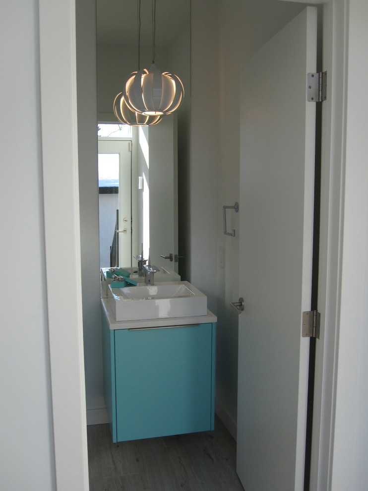 Imagen de aseo actual con lavabo sobreencimera, encimera de cuarzo compacto, armarios con paneles lisos y paredes blancas