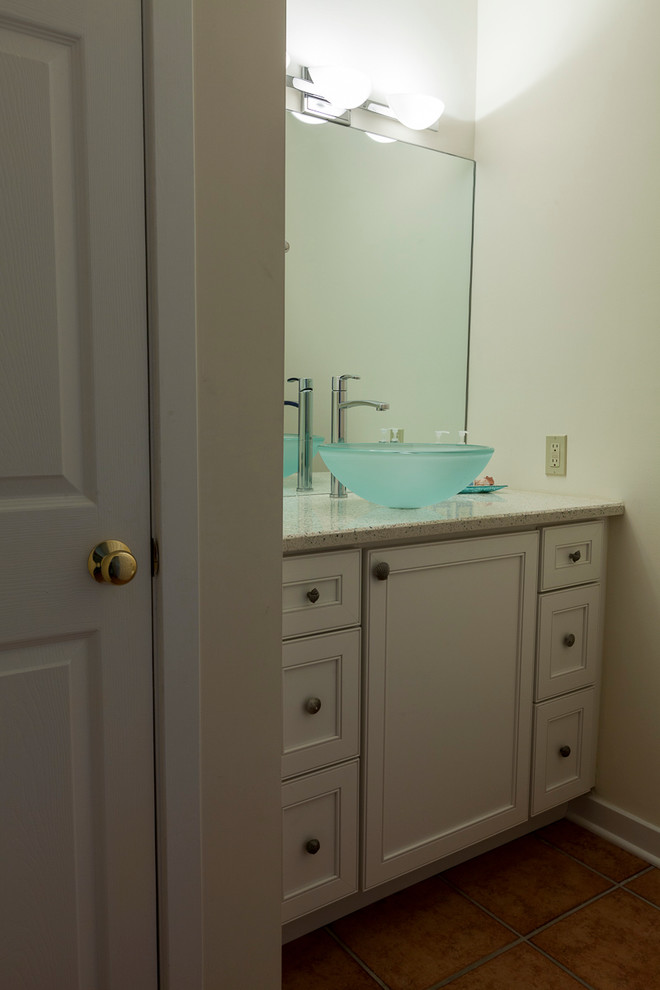 Small beach style cloakroom in Bridgeport with a vessel sink, recessed-panel cabinets, white cabinets, recycled glass worktops, a two-piece toilet, beige walls and porcelain flooring.