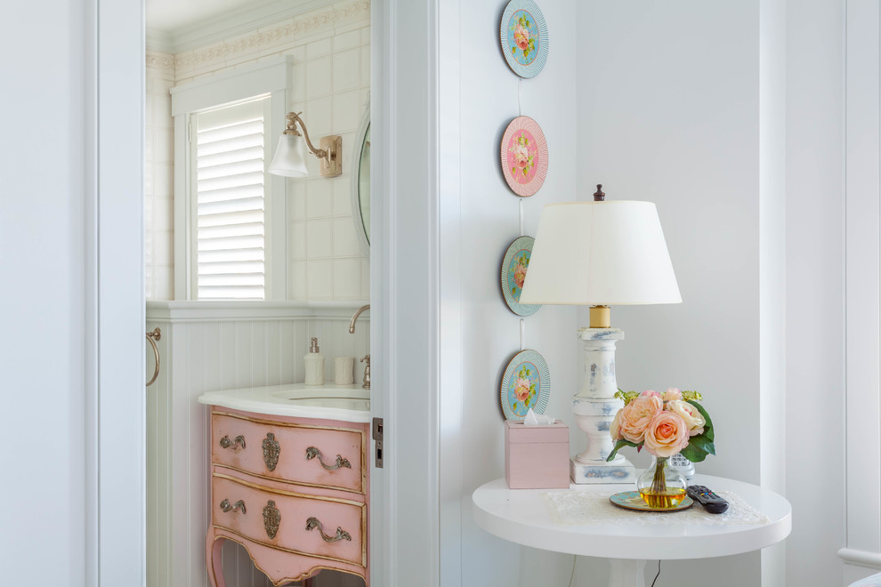 Shabby chic-inspirerad inredning av ett toalett, med ett undermonterad handfat, möbel-liknande, röda skåp, vit kakel och vita väggar