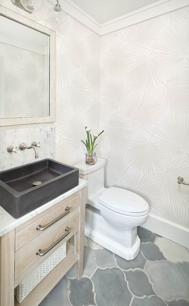 Cette image montre un WC et toilettes marin en bois clair avec un placard en trompe-l'oeil, un mur beige, une vasque, un sol gris et un plan de toilette blanc.
